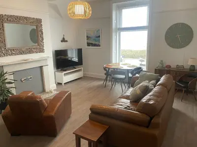 a living room with a couch and a table at Pier View in Lytham St Annes