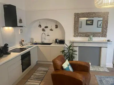 a kitchen with a couch and a chair in a room at Pier View in Lytham St Annes