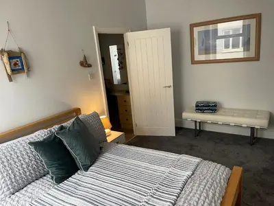 a bedroom with a bed and a table and a mirror at Pier View in Lytham St Annes