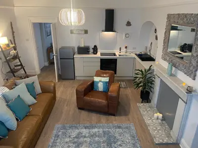 a living room with a couch and a kitchen at Pier View in Lytham St Annes