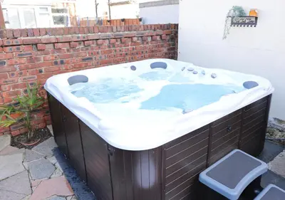 a jacuzzi tub in a backyard with a brick wall at XxHot Tub pleasure beach Sleeps 5 Xx in Blackpool