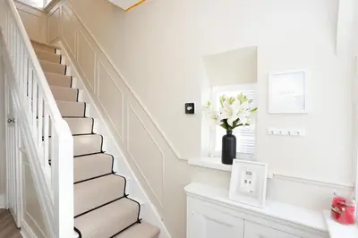 a white staircase in a home with a vase of flowers at XxHot Tub pleasure beach Sleeps 5 Xx in Blackpool