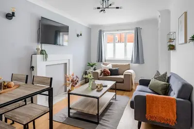 a living room with a couch and a table at Cozy Haydock Home With Easy Transport Links in St Helens and Wi-Fi in Haydock