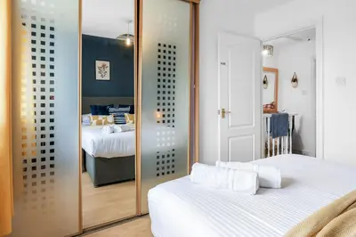a bedroom with two beds and a mirror at Cozy Haydock Home With Easy Transport Links in St Helens and Wi-Fi in Haydock
