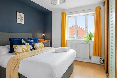 a bedroom with a large bed and a window at Cozy Haydock Home With Easy Transport Links in St Helens and Wi-Fi in Haydock