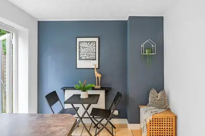 a dining room with blue walls and a table and chairs at Cozy Haydock Home With Easy Transport Links in St Helens and Wi-Fi in Haydock