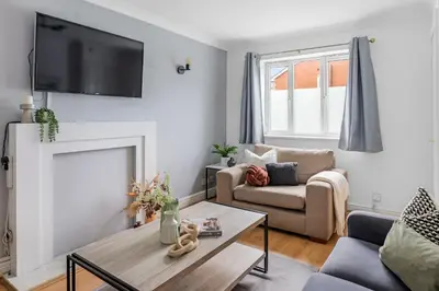 a living room with a fireplace and a tv on the wall at Cozy Haydock Home With Easy Transport Links in St Helens and Wi-Fi in Haydock