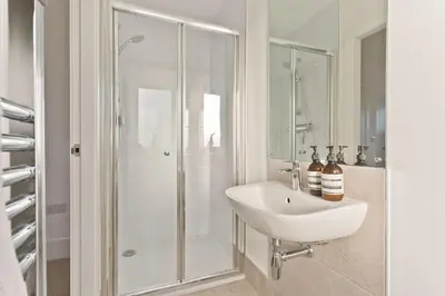 a white bathroom with a sink and a shower at Fellbeck Holiday Home - Cartmel in the Lake District in Cartmel