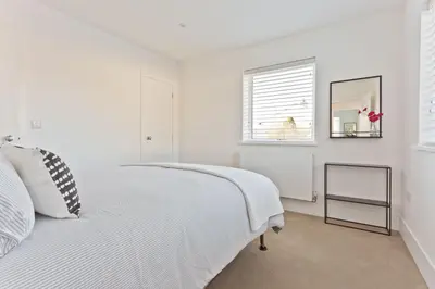 a white bedroom with a white bed and a window at Fellbeck Holiday Home - Cartmel in the Lake District in Cartmel