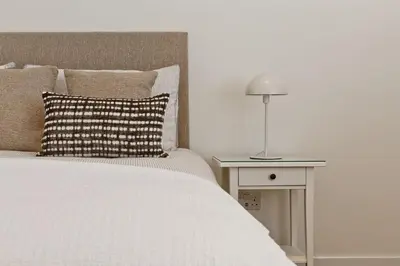 a bedroom with a bed and a table with a lamp at Fellbeck Holiday Home - Cartmel in the Lake District in Cartmel
