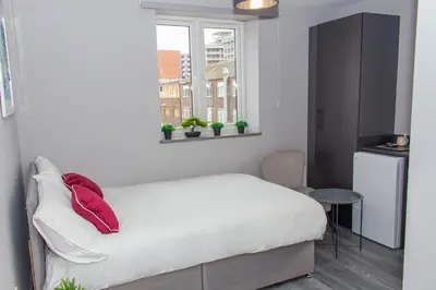 a bedroom with a bed with red pillows and a window at Mammut House in Liverpool