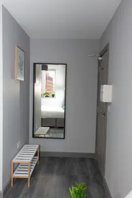 a mirror in a room with a bench and a bed at Mammut House in Liverpool