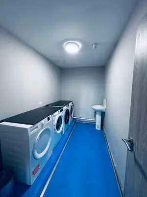 a washing machine in a room with a blue floor at Mammut House in Liverpool