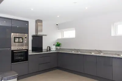 a kitchen with gray cabinets and a stove top oven at Mammut House in Liverpool