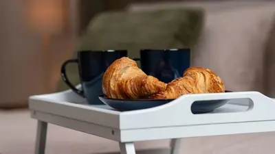 a plate of croissants and two cups on a table at Links Apartment, Southport, Englands Golf Coast in Southport