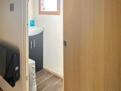 a door to a bathroom with a sink and a television at Croft - Uk50042 in Clitheroe