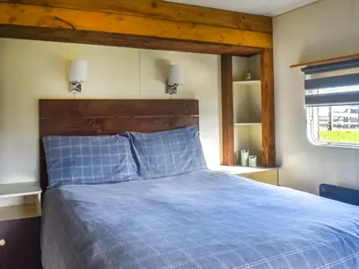 a bedroom with a blue bed with a wooden headboard at Croft - Uk50042 in Clitheroe