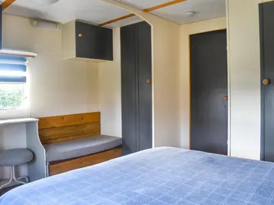 a bedroom with a bed and a chair and a window at Croft - Uk50042 in Clitheroe