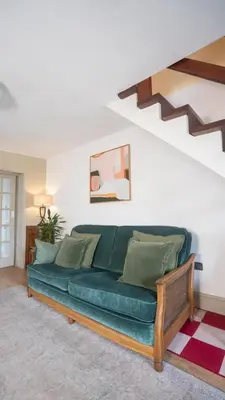 a green couch in a living room with a staircase at Tastefully decorated 3 bed home in Formby