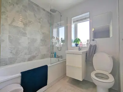 a bathroom with a toilet and a tub and a sink at Spacious 5BR Home Near Central Liverpool Parking in Liverpool