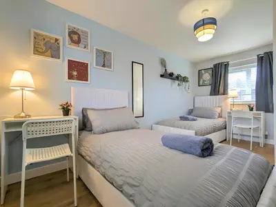 a bedroom with two beds and a desk at Spacious 5BR Home Near Central Liverpool Parking in Liverpool