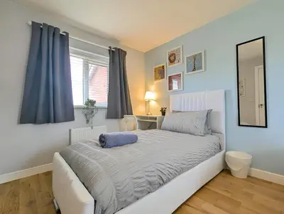 a bedroom with a bed with a mirror and a window at Spacious 5BR Home Near Central Liverpool Parking in Liverpool