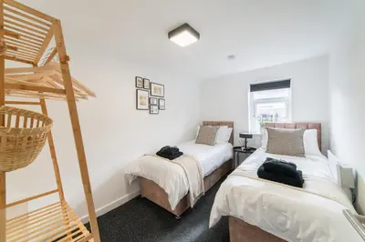 a bedroom with two beds and a bunk bed at Cosy 2 bed flat in Merseyside in Southport