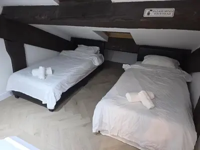 two beds in a room with white sheets and pillows at Liverpool Penthouse - Sleeps 8 - City Centre in Liverpool