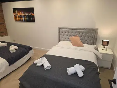 a bedroom with a bed with two towels on it at Liverpool Penthouse - Sleeps 8 - City Centre in Liverpool