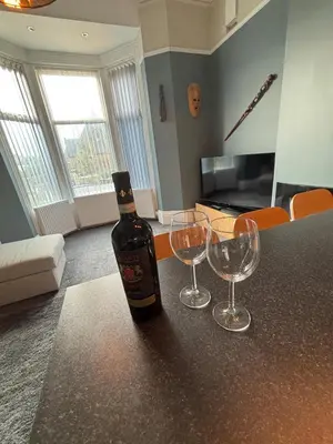 a bottle of wine sitting on a counter with two wine glasses at Shannon suite- Home away from Home-suitable for couples, contractors and NHS- free parking in Southport