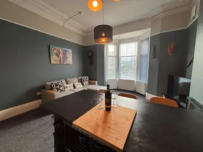 a living room with a couch and a table at Shannon suite- Home away from Home-suitable for couples, contractors and NHS- free parking in Southport