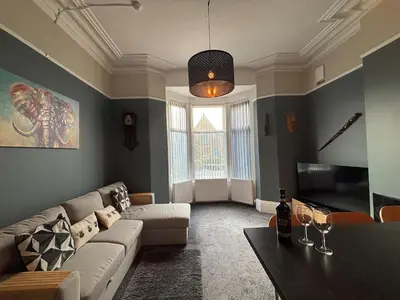 a living room with a couch and a table at Shannon suite- Home away from Home-suitable for couples, contractors and NHS- free parking in Southport