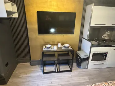 a small table in a kitchen with a tv at Reads Avenue - Luxury Ground Floor Studio - Next Door to H&A Social Club in Blackpool