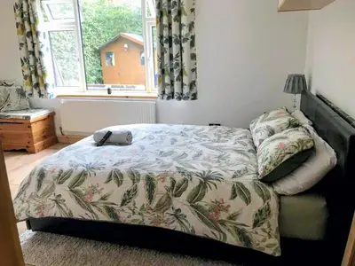 a bedroom with a bed and a window at Peaceful Large Double Room l 55inch TV l Garden View in Egerton