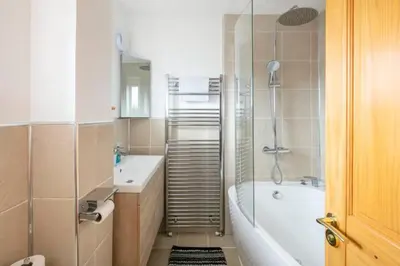a bathroom with a tub and a toilet and a sink at Peaceful Large Double Room l 55inch TV l Garden View in Egerton