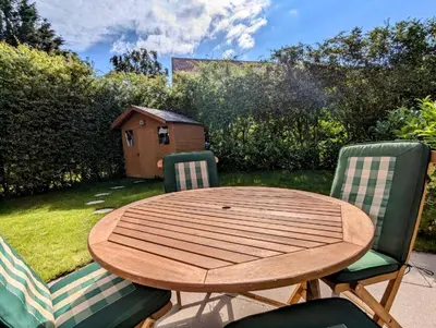 a wooden table and two chairs with a table and a yard at Peaceful Large Double Room l 55inch TV l Garden View in Egerton