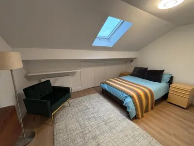 a bedroom with a bed and a window and a chair at Bedford Guesthouse in Liverpool