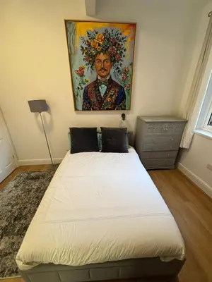 a bedroom with a bed with a painting on the wall at Bedford Guesthouse in Liverpool