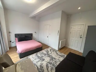 a bedroom with a pink bed and a couch at Bedford Guesthouse in Liverpool