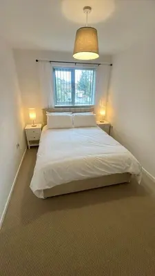 a bedroom with a large white bed with a window at Modern House on the Mersey in Wallasey
