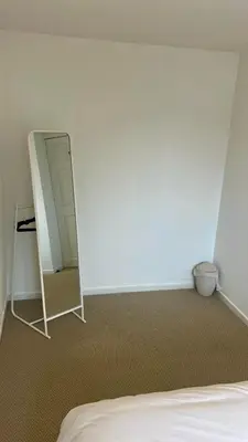 a bedroom with a mirror next to a bed at Modern House on the Mersey in Wallasey