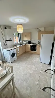 a kitchen with a white refrigerator and a dishwasher at Modern House on the Mersey in Wallasey