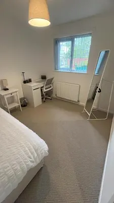 an empty room with a bed and a desk and a desk at Modern House on the Mersey in Wallasey