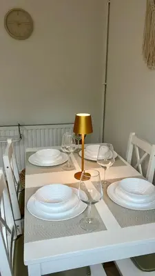 a table with white plates and wine glasses on it at Modern House on the Mersey in Wallasey