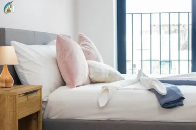 a bed with pink and white pillows on it at Oriel Nubian walls in Liverpool