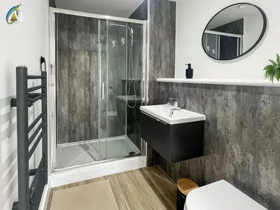 a bathroom with a shower and a sink and a mirror at Oriel Nubian walls in Liverpool