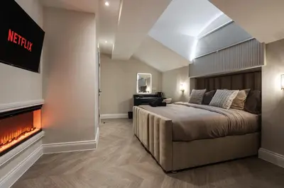a bedroom with a large bed and a fireplace at Bold St ApartHotel Book Individually or Book 8! in Liverpool