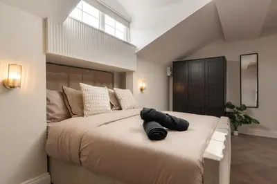 a bedroom with a large bed with black shoes on it at Bold St ApartHotel Book Individually or Book 8! in Liverpool