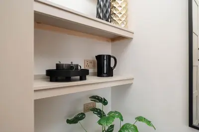 a shelf with two cups and a plant on it at Bold St ApartHotel Book Individually or Book 8! in Liverpool