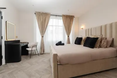 a bedroom with a large white bed and a desk at Bold St ApartHotel Book Individually or Book 8! in Liverpool